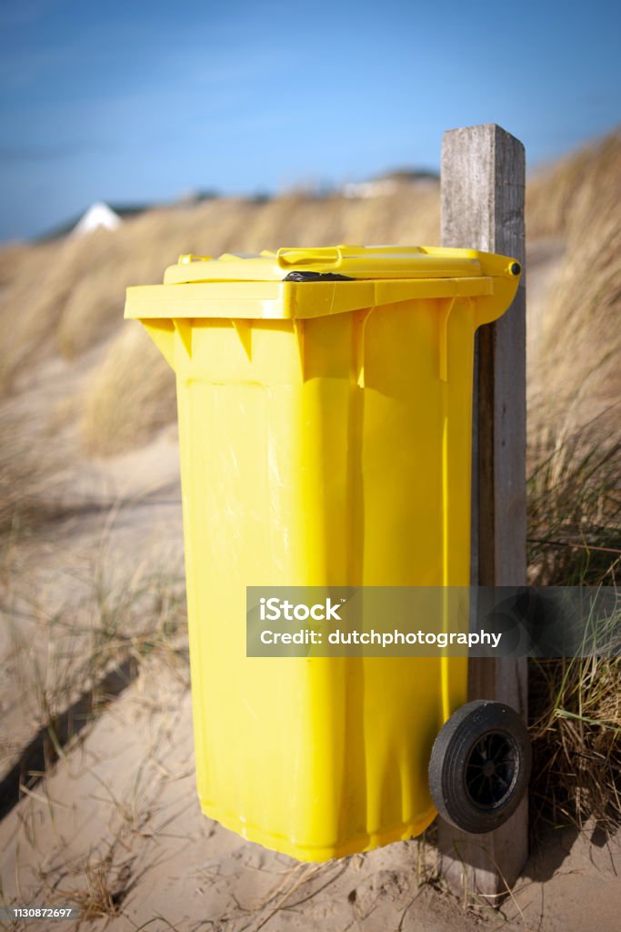 Yellow waste container on the beach Gele afvalcontainer op het strand Garbage Bin Stock Photo