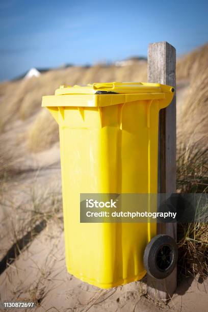 Yellow Waste Container On The Beach Stock Photo - Download Image Now - Garbage Bin, Netherlands, Beach