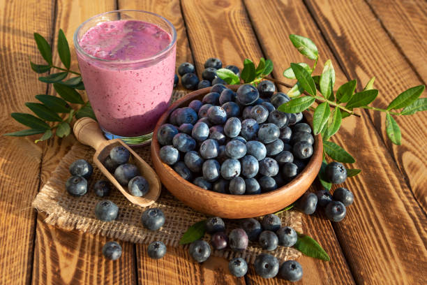 istock Blueberries smoothie with fresh berries on wooden background 1130876569