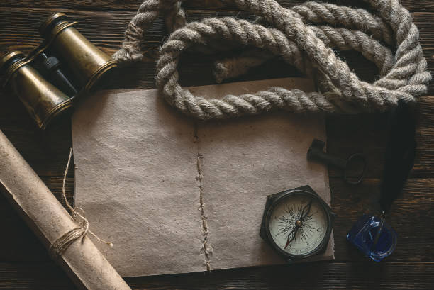 Travel. Blank traveler notebook, compass, binoculars, mooring rope and inkpot with a quill pen on a wooden table background mockup. Adventurer notes. treasure chest photos stock pictures, royalty-free photos & images