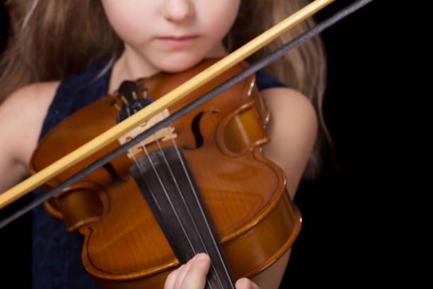 violin closeup of girl playing the violin isolated on black background - violinista imagens e fotografias de stock