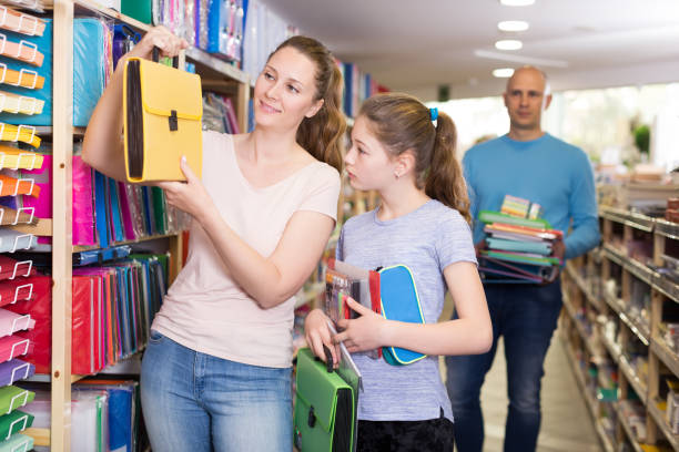 istock parents and daughter selecting school stationery 1130883433