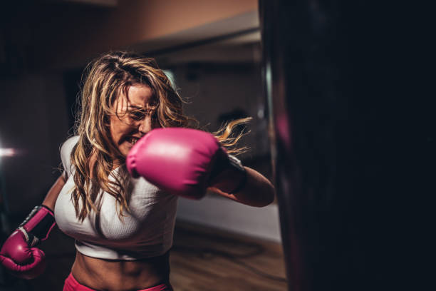 istock Tough young woman boxer training 1130883793