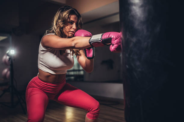 istock Woman boxer punching a punching bag 1130884370