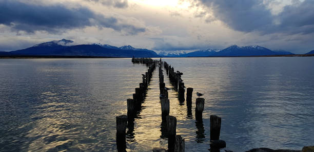 Lights of the sunset over the remains of the pier (Muelle Braun y Blanchard) in Puerto Natales, Chile stock photo