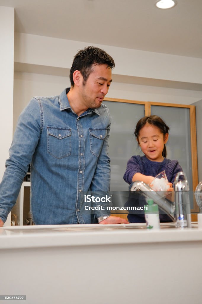 Father And Daughter Washing Dishes In Kitchen Stock Photo - Download