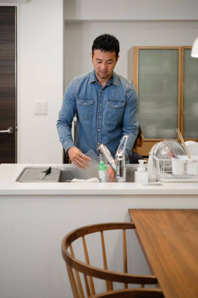 istock Man washing dishes in kitchen 1130888811