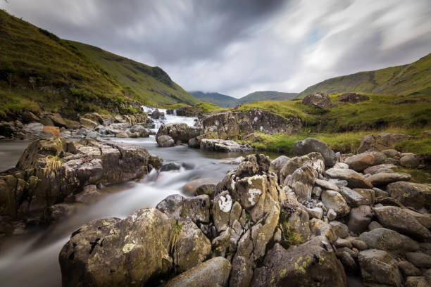 Dark and moody overcast over waterfall with long exposure Lake District England