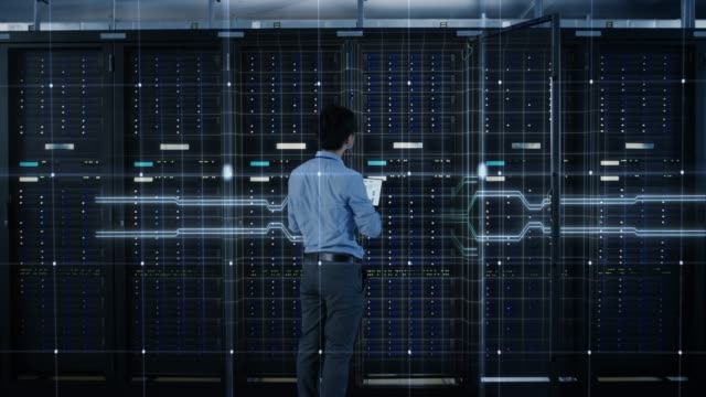 IT Specialist Standing In front of Server Racks with Laptop, He Activates Data Center with a Touch Gesture. 3D Animated Concept of Digitalization: Network of Lines Spreading Symmetrically. Zoom Out