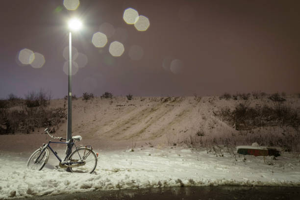 an empty hill slope in the snow with an abandoned bike netherlands - lantarn imagens e fotografias de stock