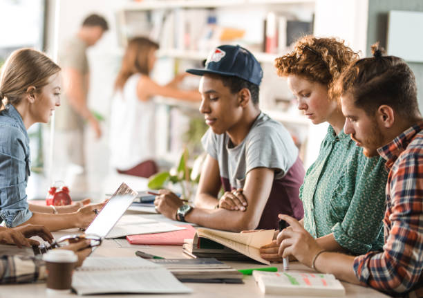 istock Group of college students learning in team in a library. 1130889744