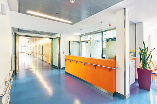 Corridor in a hospital with counter reception bright and sunny no one