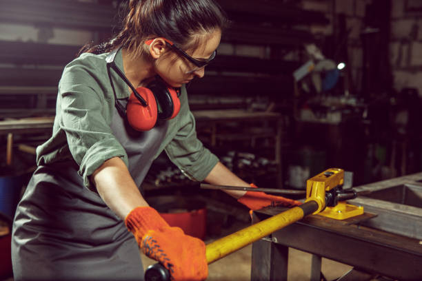 istock Busy and serious craftswoman grinding timbers with special machine. 1130892446