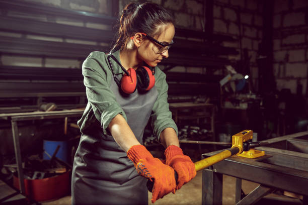 istock Busy and serious craftswoman grinding timbers with special machine. 1130892453