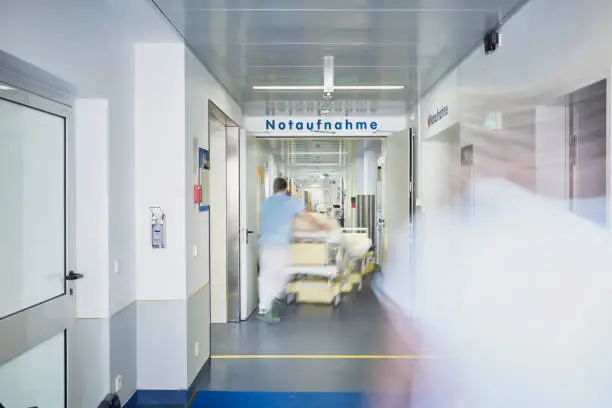 Emergency admission entrance hospital with a doctor in motion blur on the corridor pushing a bed