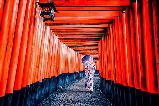 Girl with traditional dress in Fushimi Inari Taisha shrine in Kyoto, Japan