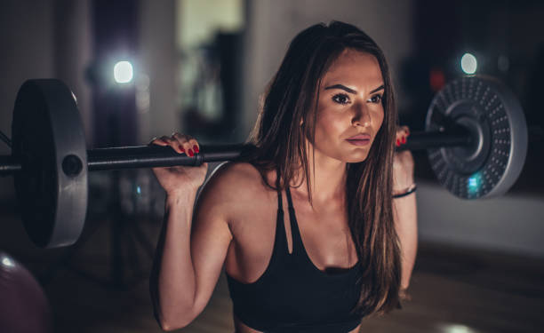 istock Beautiful brunette woman training with weights in gym 1130895491