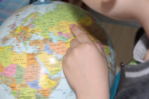 istock The child is studying geography. Finger pointing to the globe. 1130897418