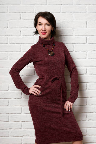 istock Beautiful woman posing near white brick wall background 1130898566