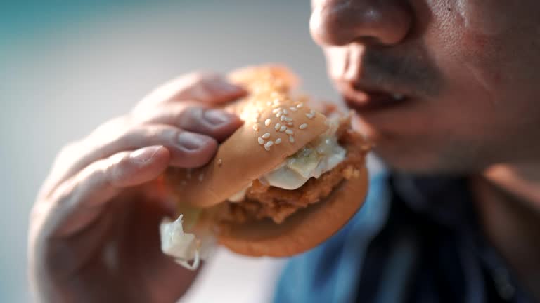 Close up shot men are eating hamburgers. happily