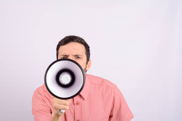 istock Young man screaming on a megaphone. 1130903035
