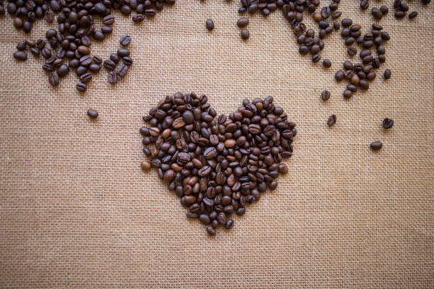 黄麻布のコーヒー豆のハートシェイプ - coffee crop bean seed directly above ストックフォトと画像