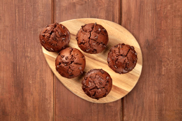 muffin al cioccolato, girati dall'alto su uno sfondo di legno rustico scuro con spazio di copia - vegan food cake muffin chocolate foto e immagini stock