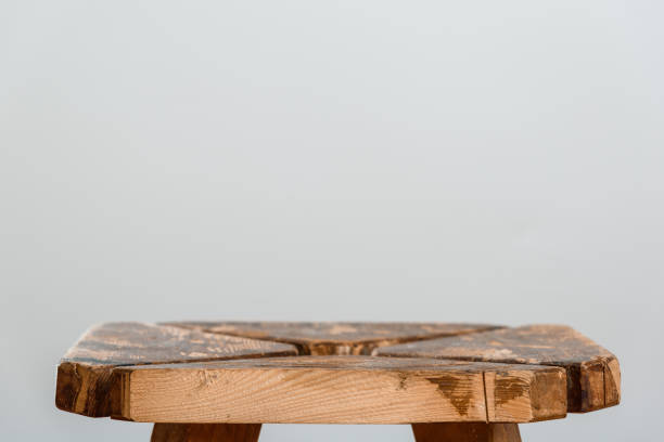 istock Empty rough wooden table top of old stool in blur on a gray background. Side cut close-up. Photo with for copy space. 1130906209