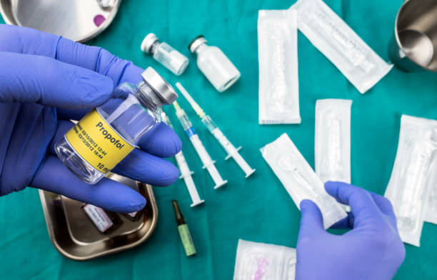 Nurse preparing hospital medication, Left hand holding propofol vial, conceptual image, horizontal composition stock photo