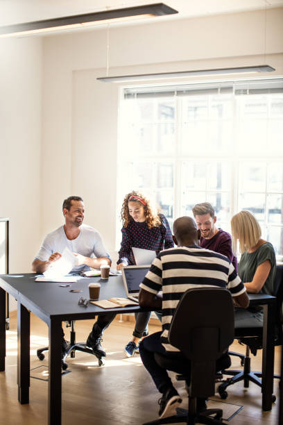 istock Designers discussing work together around an office table 1130908905
