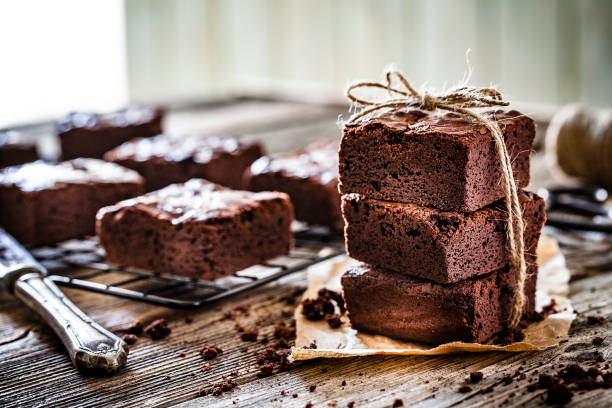 домашние шоколадные пирожные, снятые на деревенском деревянном столе - baking brown cake chocolate стоковые фото и изображения