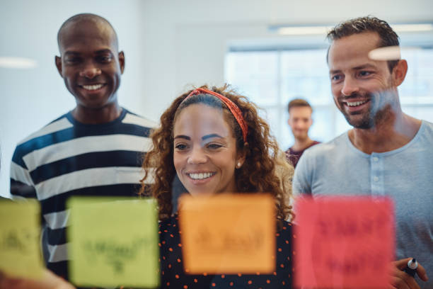 istock Smiling work colleagues brainstorming with sticky notes in an office 1130911808