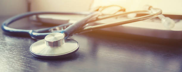Stethoscope and laptop keyboard on desktop in hospital,relax time doctor,medical concept,selective focus,vintage color.morning light,banner stock photo