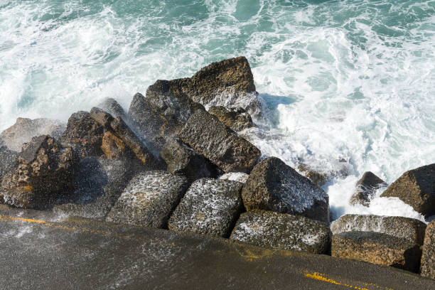 istock The waves breaking on a stony beach, forming a spray. Wave and splashes on beach. Waves crashing onto rocks. 1130913139