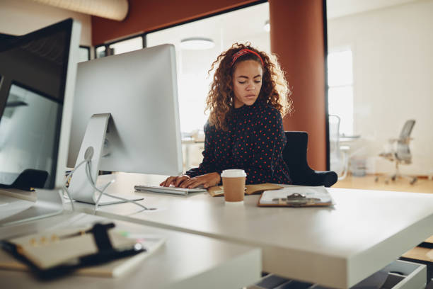 istock Young businesswoman reading notes at her office workstation 1130913465