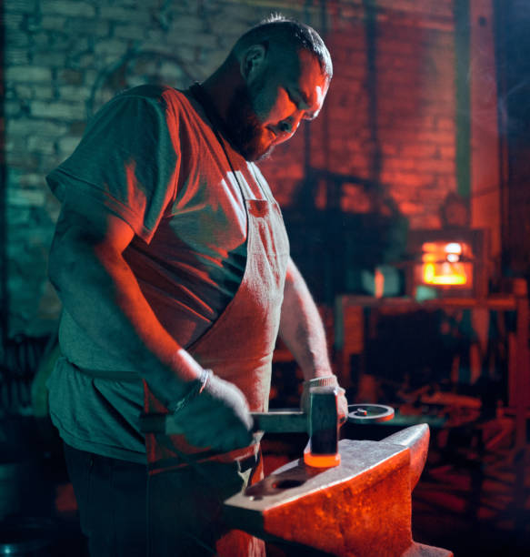 istock Strong Blacksmith Is Hitting Red Hot Metal Rod In Blacksmith Shop 1130913773