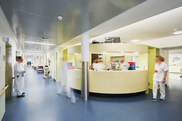 Emergency admission hospital with a doctor in motion blur on the corridor waiting and standing and many other doctors and nurses as a team
