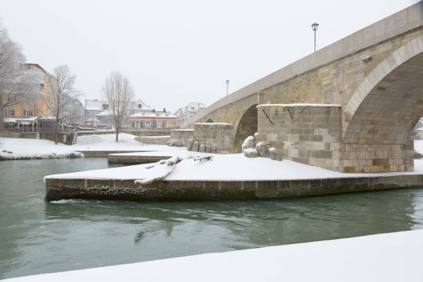 next to the steinerne bridge regensburg, germany in winter, - arch bridge regensburg ancient germany imagens e fotografias de stock