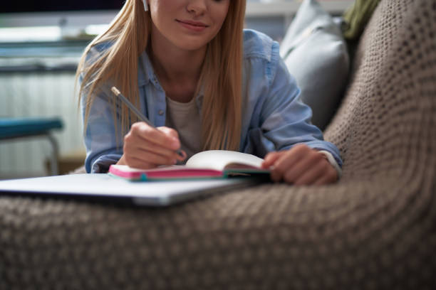 istock Beautiful young lady in blue shirt writing on notebook 1130914920