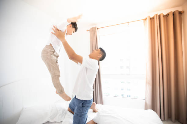 istock Father And Son Playing On Bed At Home 1130916521