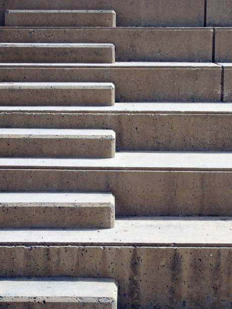 istock Modern outdoor concrete ascending steps with raised area for seating in contrasting sunlight and shadow 1130916636