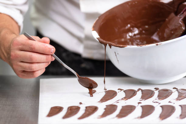 istock Professional confectioner making chocolate sweets at confectionery shop. 1130916642