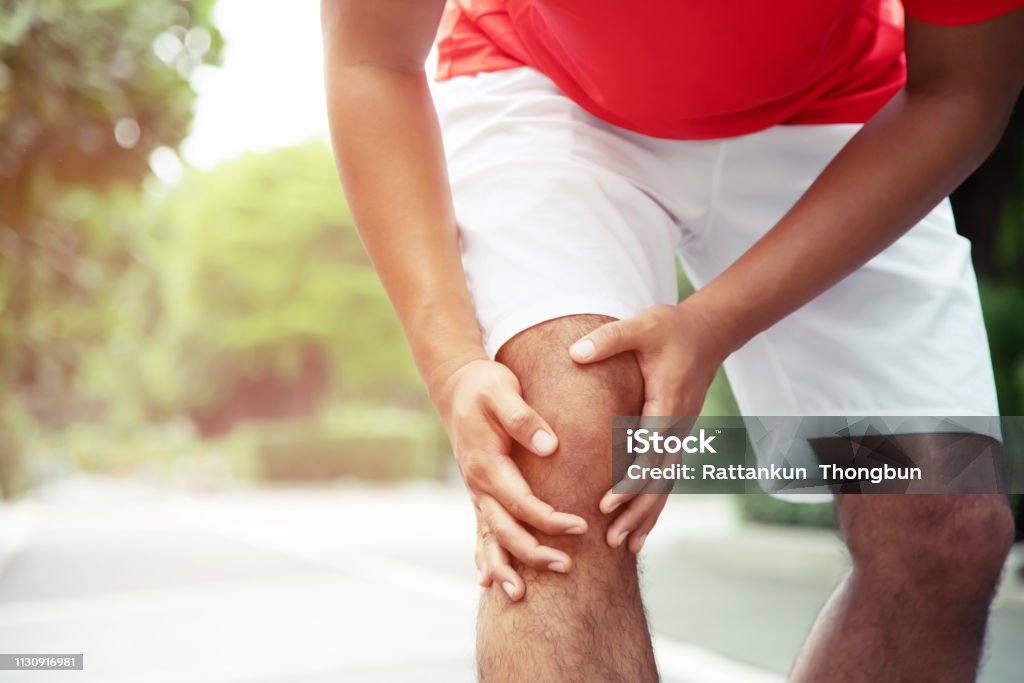 Runner touching painful twisted or broken ankle. Athlete runner training accident. Sport running ankle sprained sprain cause injury knee. and pain with leg bones. Focus color red on to show pain. Adult Stock Photo