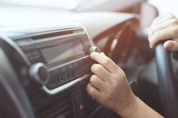 閉手打開汽車收音機聽。汽車司機改變轉向按鈕電臺在他的車輛多媒體系統。現代觸控式螢幕音響身歷聲系統。運輸和車輛概念 - radio 個照片及圖片檔