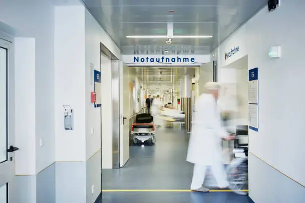 Emergency admission entrance hospital with doctor wheelchair and patient in motion blur in the corridor
