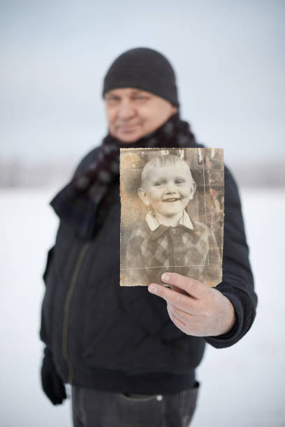 istock Aged man with his photo as child 1130919174