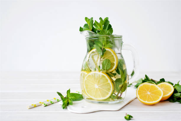istock Lemonade in glass jug on light background 1130919912
