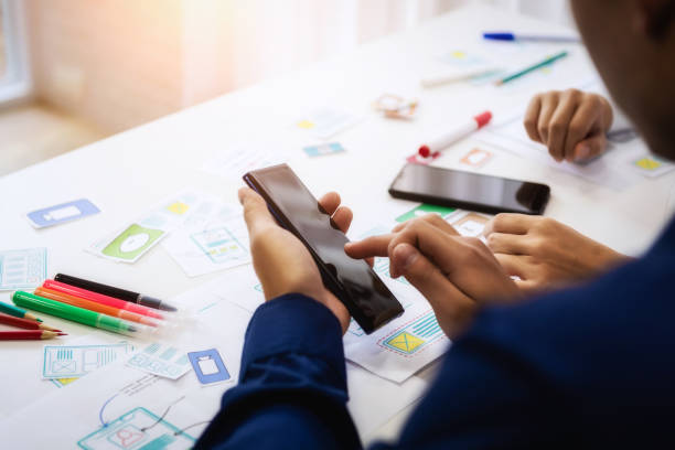 Group of people designers mobile application working wireframe sketch drawing application in office. Teamwork  user experience Design concept.