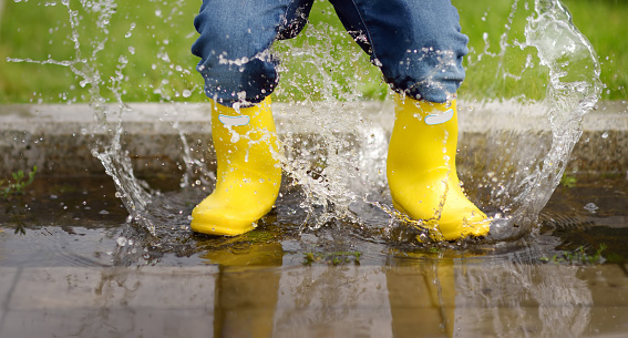 Toddler jumping in pool of water at the summer or autumn day. Outdoors activity for kids.