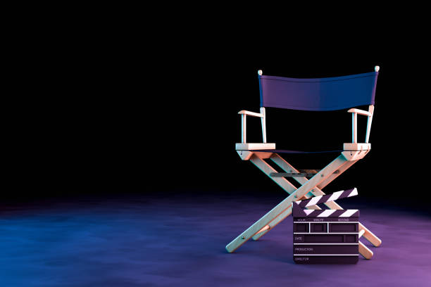 director chair y movie clapper con luces de neón sobre fondo negro - silla de director fotografías e imágenes de stock